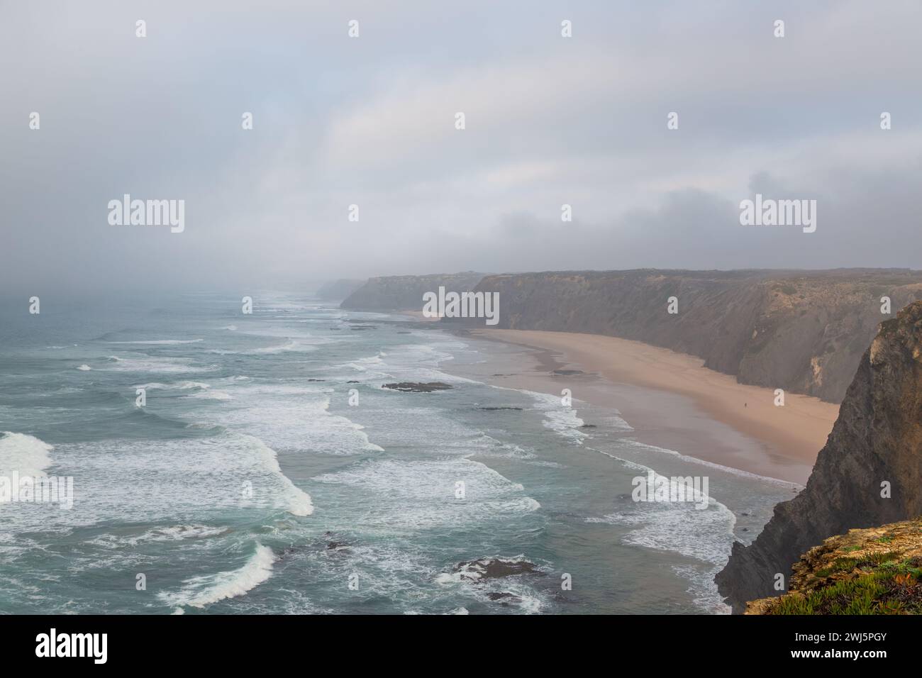 Guarda giù le scogliere verso il mare da una spiaggia vicino ad Aljezur in Portogallo Foto Stock