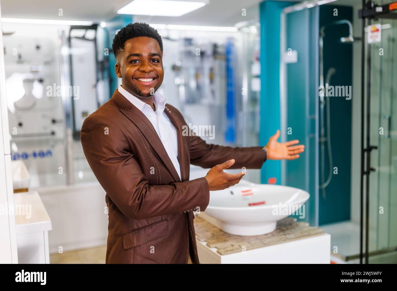 Ritratto del venditore nel negozio di articoli da bagno. L'uomo felice lavora in un negozio di bagni. Occupazione delle vendite. Foto Stock