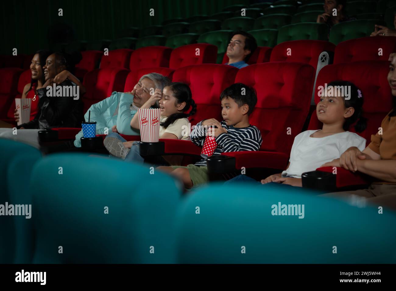 Madre e figlia asiatiche che guardano film al cinema. Concetto del tempo per la famiglia. Foto Stock