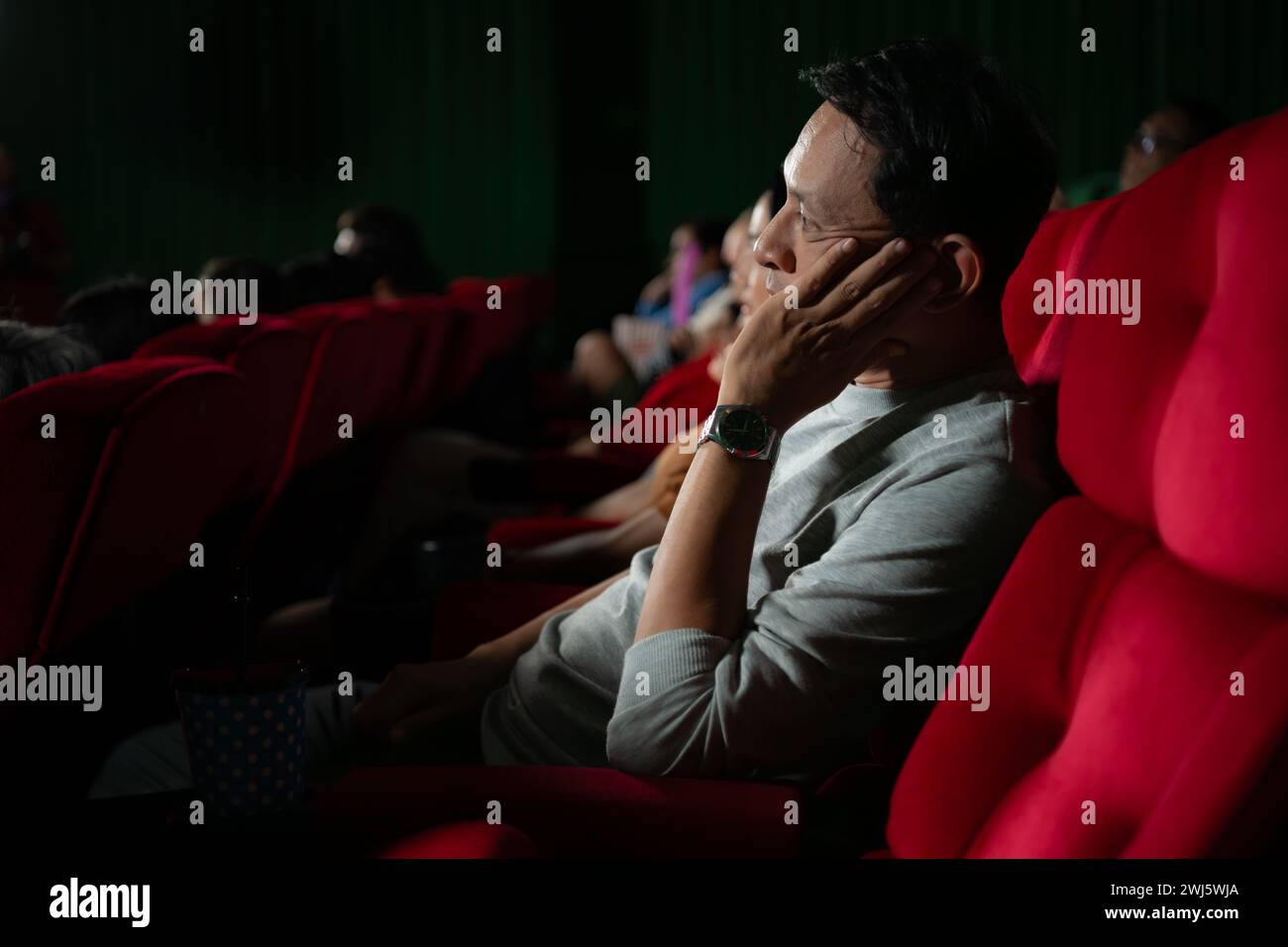 Madre e figlia asiatiche che guardano film al cinema. Concetto del tempo per la famiglia. Foto Stock