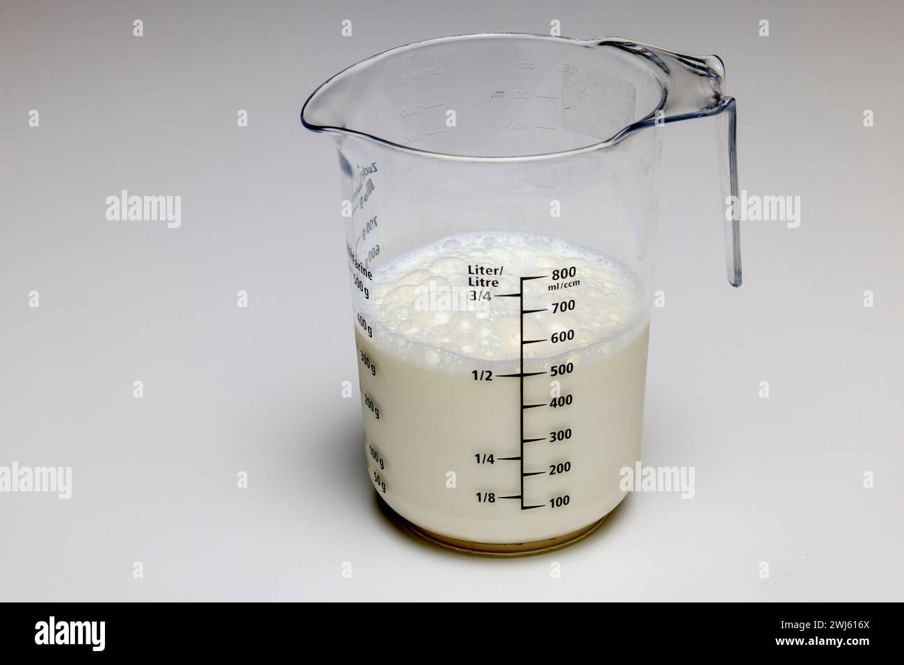 un contenitore con latte graduato per la misurazione. Foto Stock