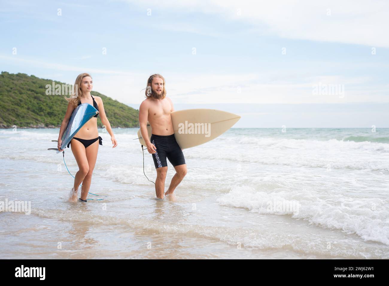 Giovane uomo e donna con tavole da surf pronti a camminare in mare per fare surf. Foto Stock