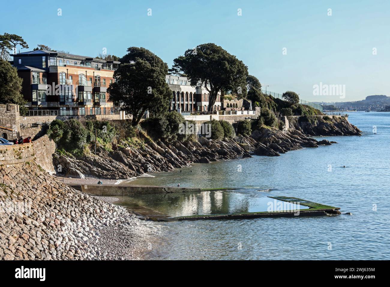 La piscina del mare di Devil’s Point a Plymouth. L'acqua di mare entra sopra il muro della piscina con una marea di primavera strisciante nel febbraio 2024. Firestone Bay e Drakes Island Foto Stock