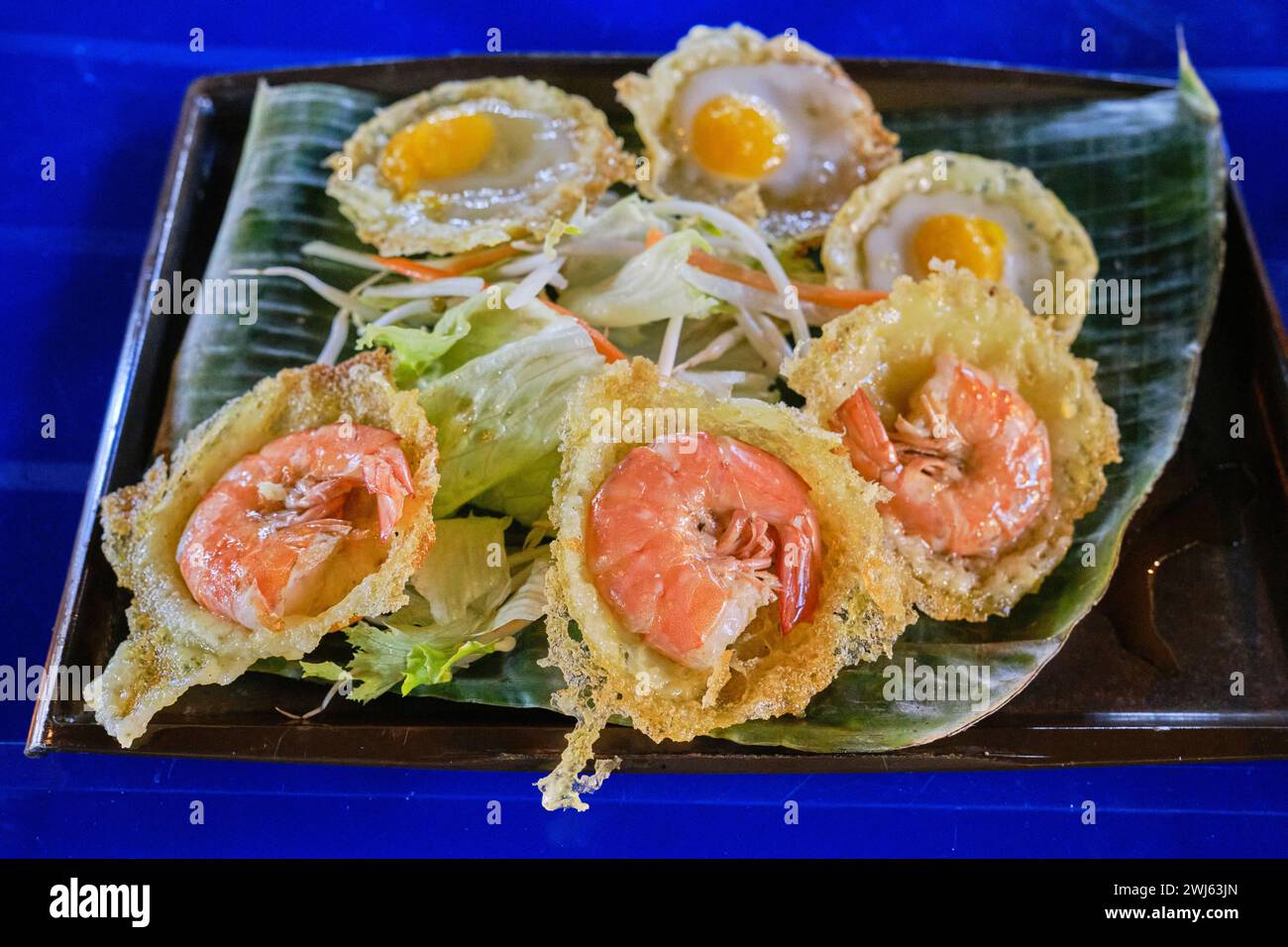 Mini pancake salati vietnamiti (banh khot / bánh khọt). Questi sono conditi con gamberetti e uova di quaglia con salsa di pesce Foto Stock