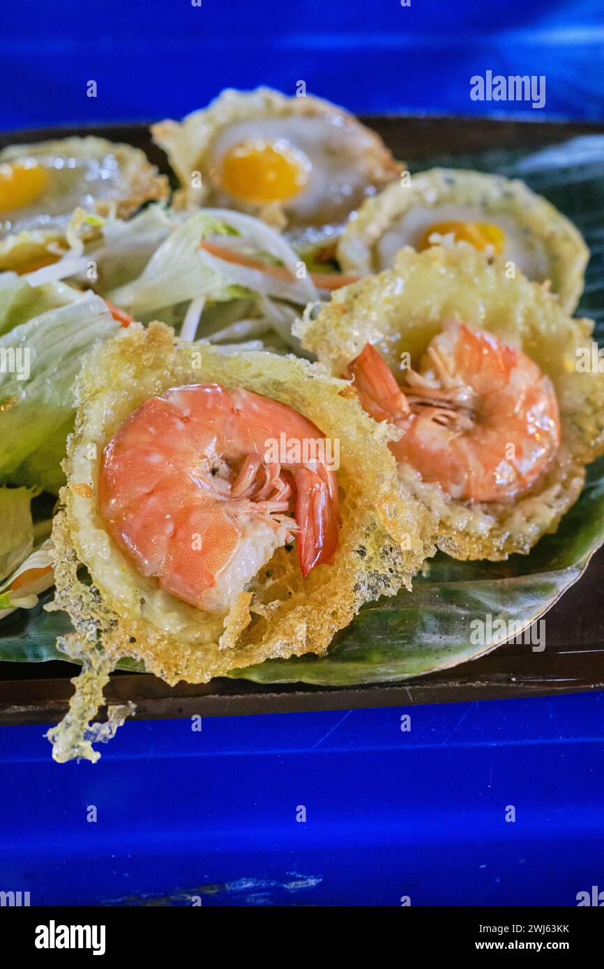 Mini pancake salati vietnamiti (banh khot / bánh khọt). Questi sono conditi con gamberetti e uova di quaglia con salsa di pesce Foto Stock