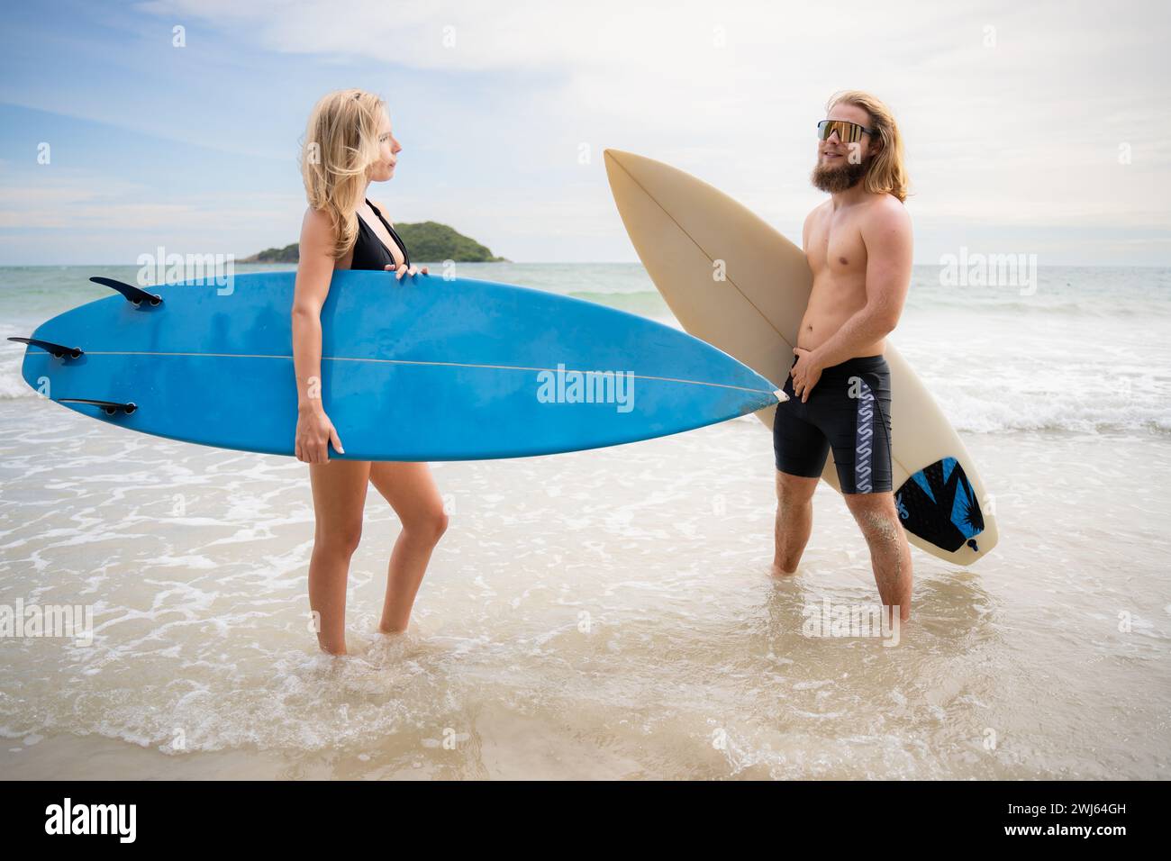 Giovane uomo e donna con tavole da surf pronti a camminare in mare per fare surf. Foto Stock