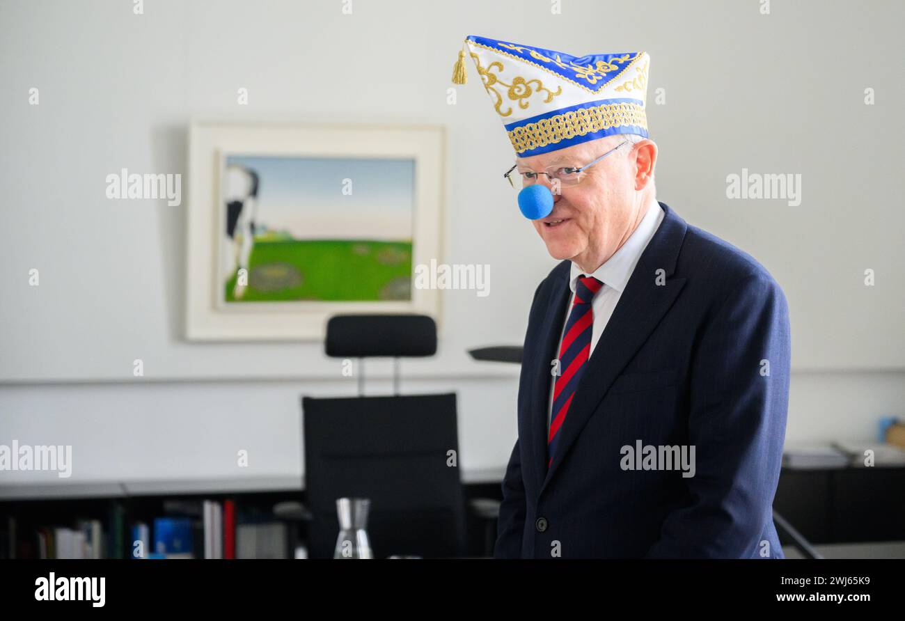 Hannover, Germania. 13 febbraio 2024. Stephan Weil (SPD), Ministro Presidente della bassa Sassonia, si trova nel suo ufficio nella Cancelleria di Stato della bassa Sassonia con indosso un cappello da giullare e un naso da clown blu. I jester di Linden hanno suonato nel carnevale della Cancelleria di Stato puntualmente alle 11,11. Credito: Julian Stratenschulte/dpa/Alamy Live News Foto Stock