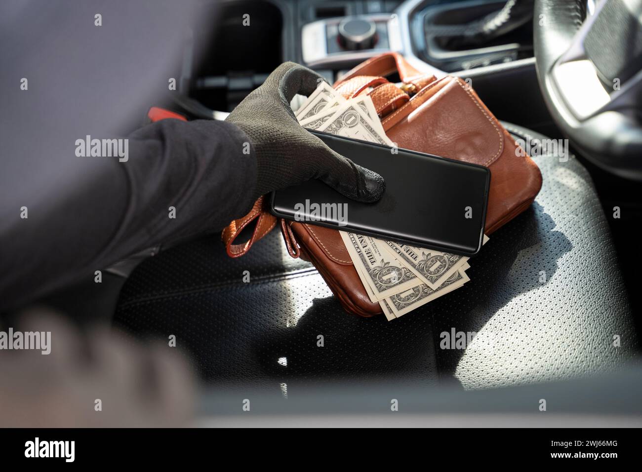 I ladri rubano portafoglio e telefono dal seggiolino per auto. Foto Stock