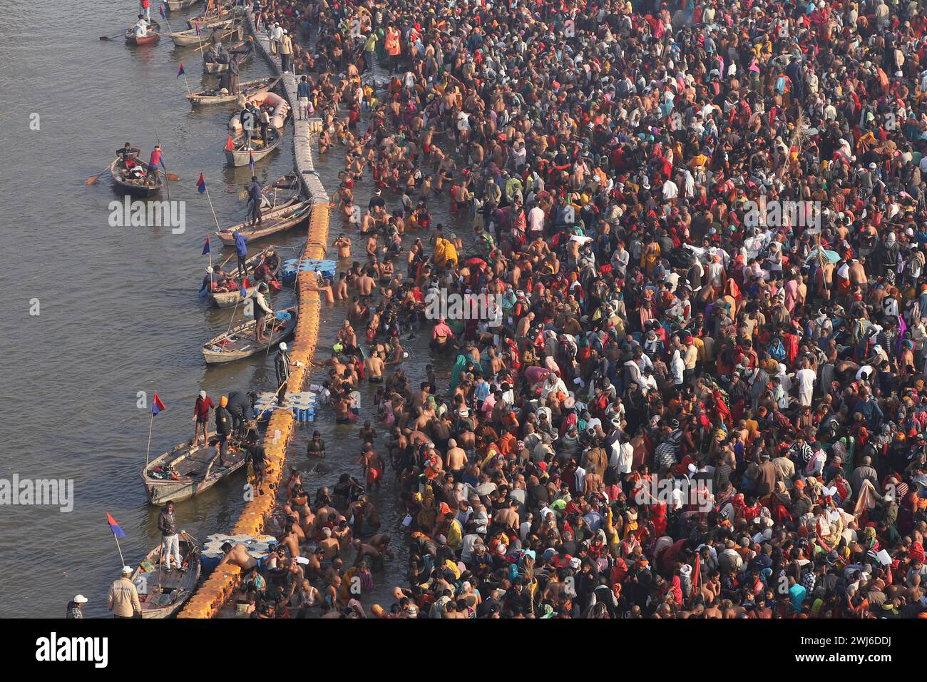 I devoti si riuniscono sulla riva del fiume Ganga per fare un bagno sacro nel fiume nel giorno di buon auspicio di Mauni Amavasya durante il "Magh Mela" a Prayagraj, in India. Foto Stock