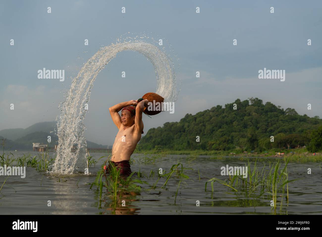 Pescatori che utilizzano attrezzature da pesca tradizionali dopo aver catturato i pesci, puliscono e giocano in acqua. Foto Stock