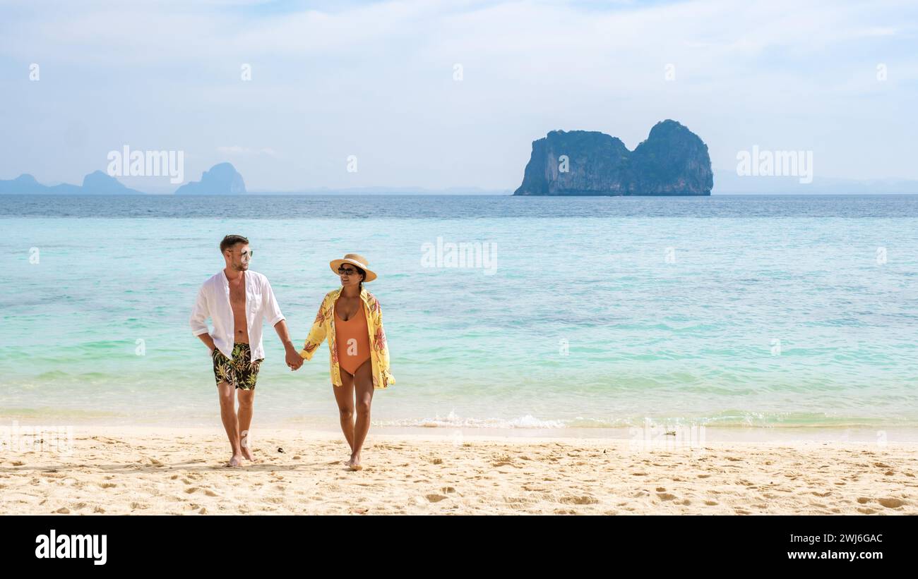 Felice giovane coppia donna asiatica e uomini europei sulla spiaggia dell'isola di Koh Ngai in Thailandia Foto Stock
