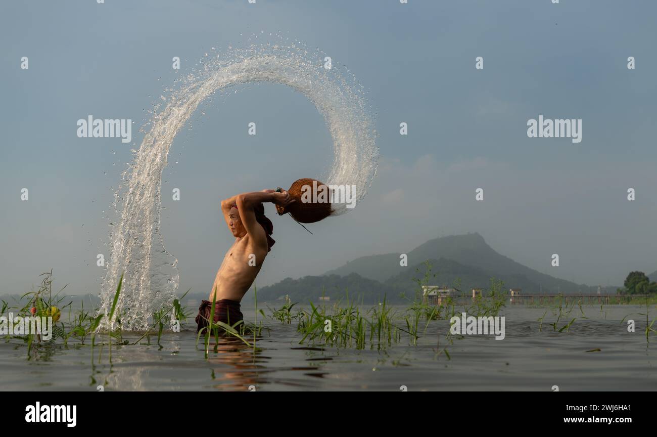 Pescatori che utilizzano attrezzature da pesca tradizionali dopo aver catturato i pesci, puliscono e giocano in acqua. Foto Stock