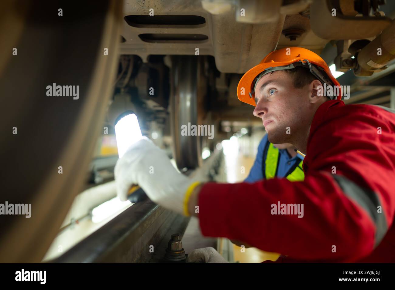 Due ingegneri per treni elettrici dopo aver rilevato difficoltà con i macchinari del treno elettrico utilizzano proiettori per localizzare un Foto Stock