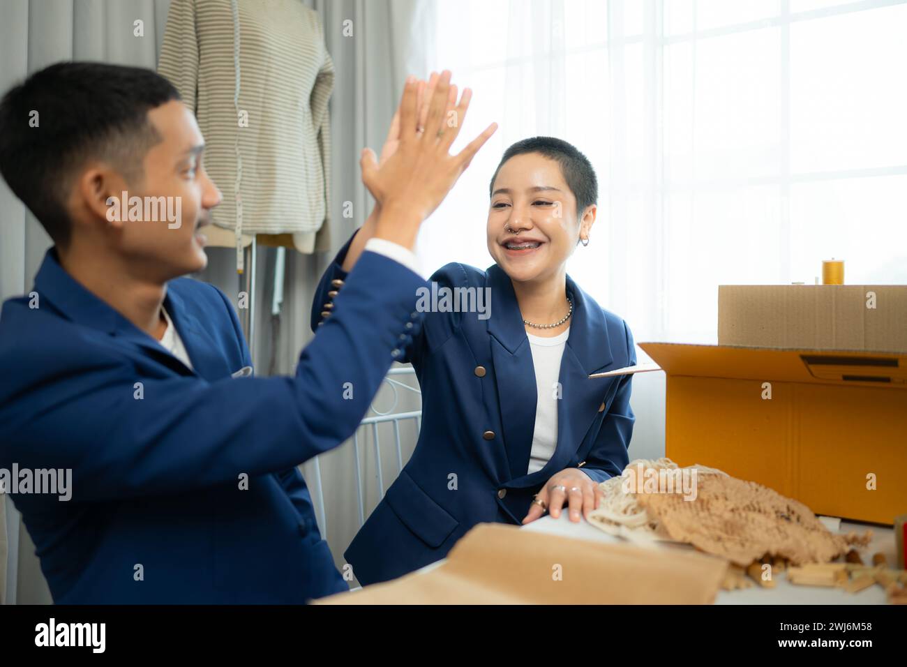 Entrambi gli stilisti asiatici che lavorano con la macchina da cucire nel negozio di abiti da sposa Foto Stock