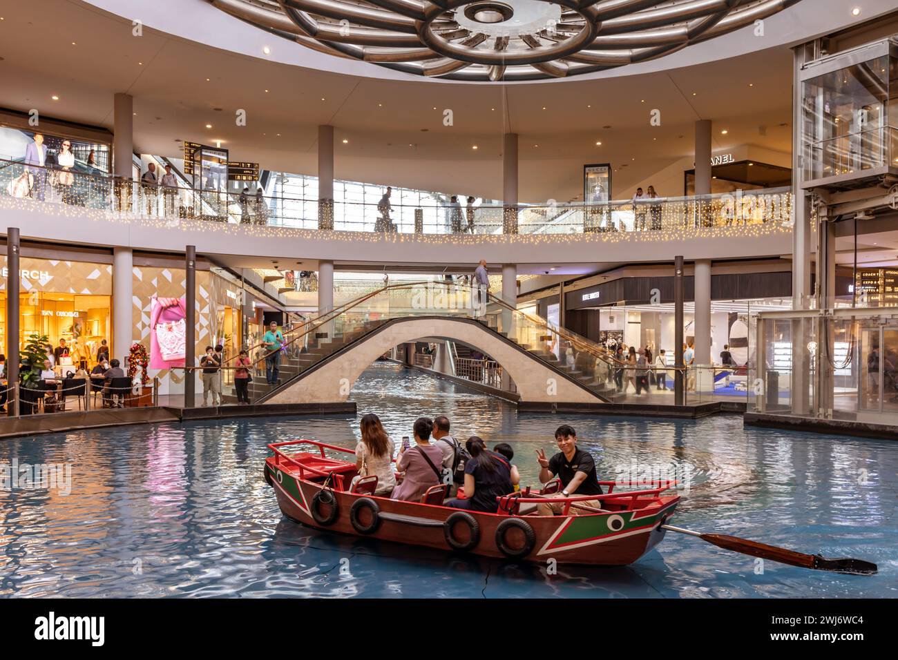 I visitatori che si godono le escursioni IN SAMPAN cavalcano lungo il Canal at the Shoppes at Marina Bay Sands. Foto Stock