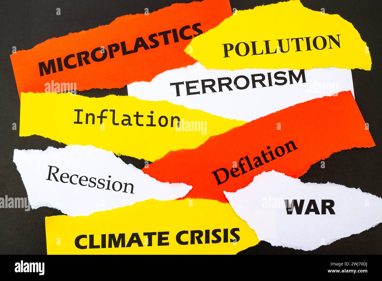 Attualità, fogli di vari colori con parole: Crisi economica, guerra, inflazione, terrorismo, ecc., su sfondo nero. Foto Stock