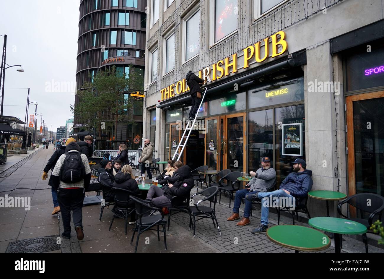 Persone fuori dall'Old Irish Pub di Copenaghen prima del turno di UEFA Champions League del 16, partita di andata al Parken Stadium di Copenaghen. Data foto: Martedì 13 febbraio 2024. Foto Stock