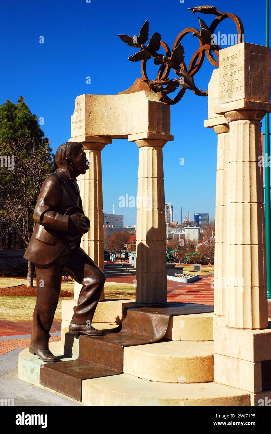 Una scultura del barone Pierre de Coubertin, fondatore dei moderni Giochi Olimpici, cammina simbolicamente attraverso le antiche colonne di Atlanta Foto Stock