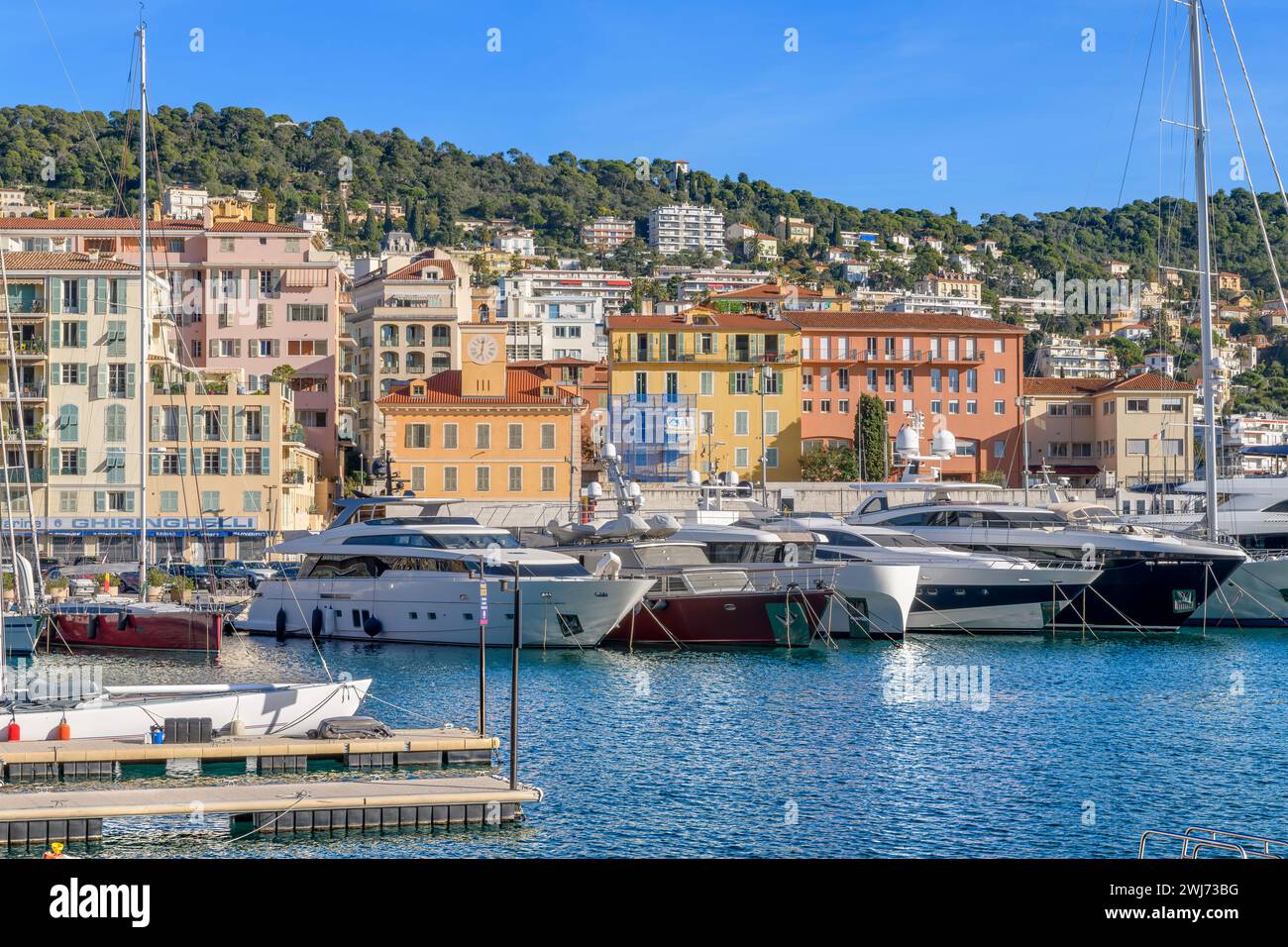 Pittoresca Port Lympia a Nizza. Con yacht di lusso e barche a remi colorate chiamate "pointus". Usate come barche da pesca e ora utilizzate anche dalle famiglie. Foto Stock