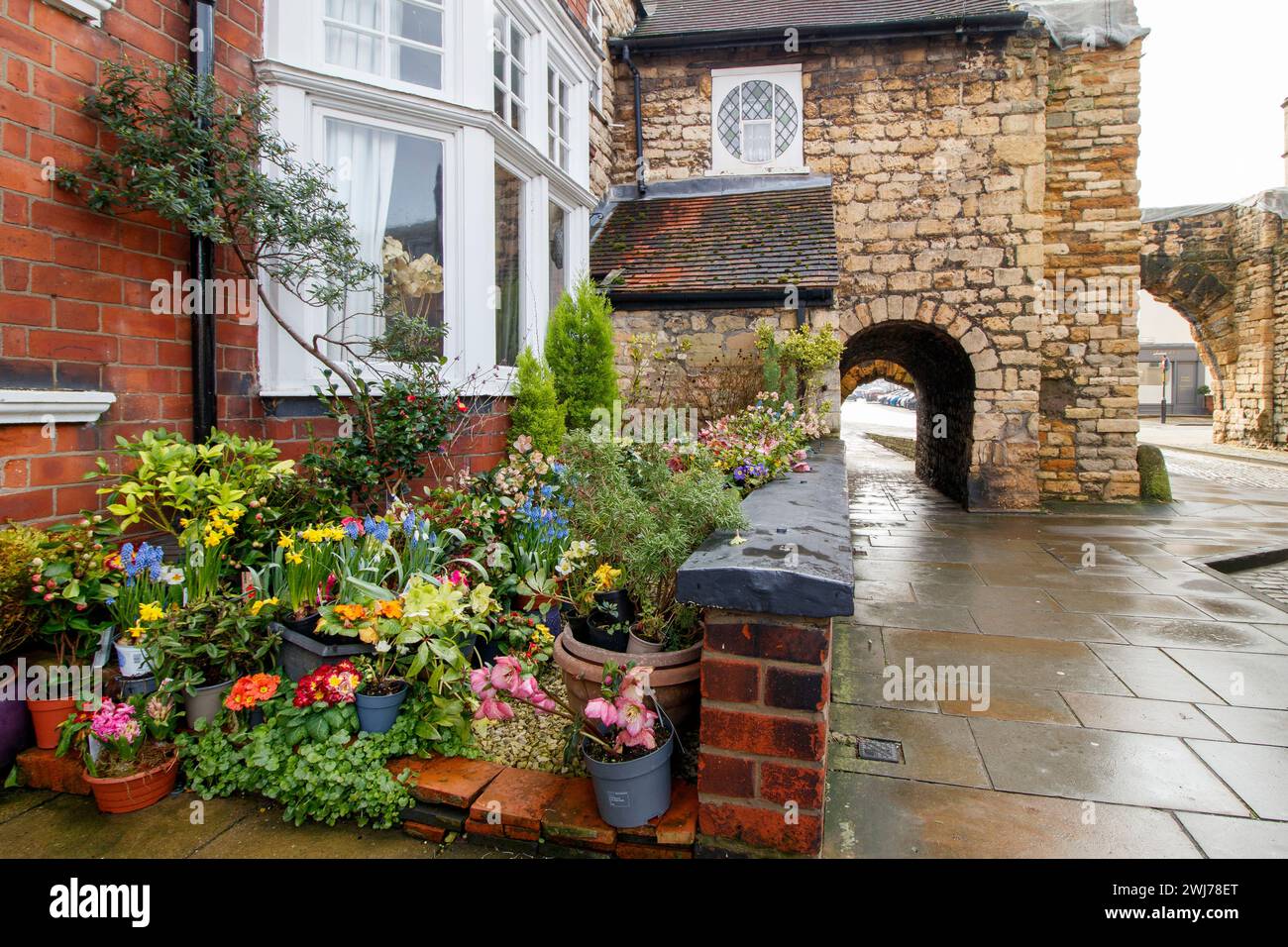 Lui Newport Arch e la strada che porta a Bailgate, l'area superiore di Lincoln. Newport Arch è una porta romana del III secolo nella città di Lincoln, nel Lincolnshire. Si tratta di un monumento e di un edificio classificato di grado i ed è considerato l'arco più antico del Regno Unito ancora utilizzato dal traffico. Foto Stock