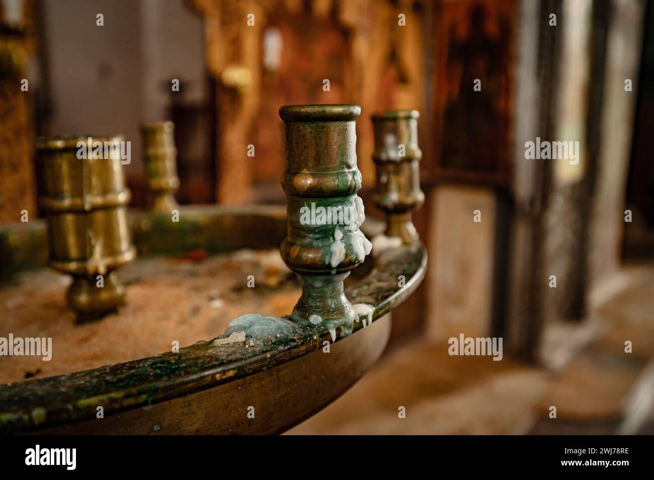 Portacandele in metallo esposto su un tavolo in legno rustico in uno spazio interno ben illuminato Foto Stock