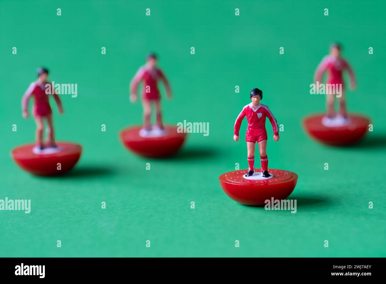 Un gruppo di figure in miniatura di Subbuteo dipinte nei colori della squadra di casa del Liverpool FC con camicia rossa, pantaloncini corti rossi e calze rosse. Foto Stock