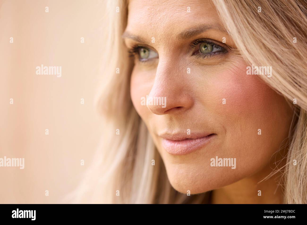 Primo piano ritratto di bellezza di donna matura sorridente su sfondo naturale Foto Stock