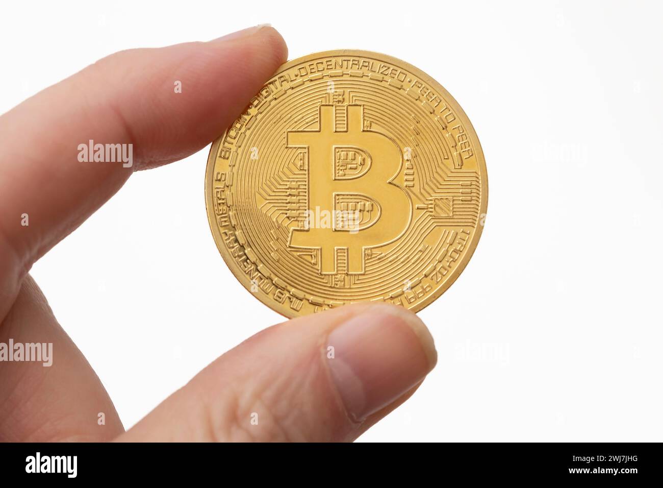 Moneta Bitcoin tra le dita Foto Stock