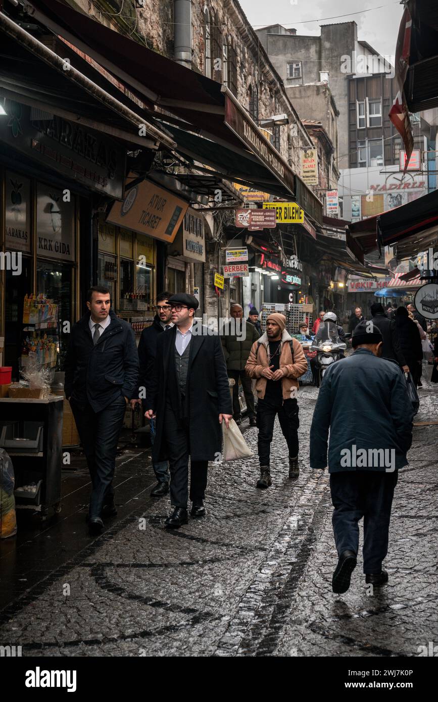 Tra gocce di pioggia e riflessi: Un'elegante passeggiata serale attraverso le strade senza tempo di Istanbul Foto Stock