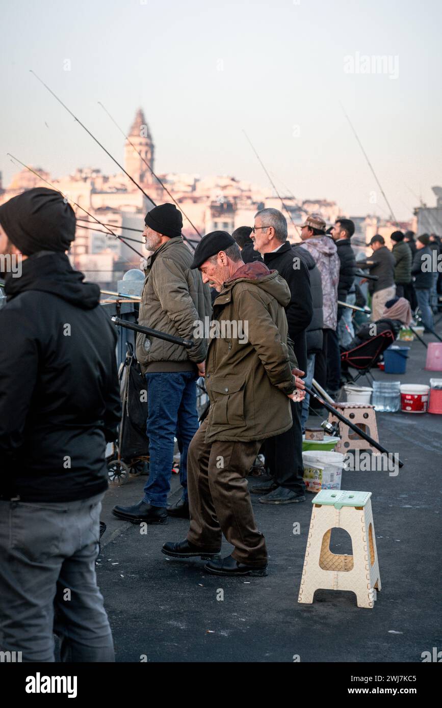 Serenità al tramonto: La tradizione senza tempo della pesca serale a Istanbul Foto Stock
