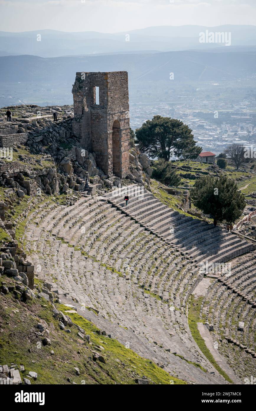 Echi dell'antichità: Una passeggiata solitaria attraverso l'anfiteatro di Pergamo con Bergama nell'orizzonte Foto Stock