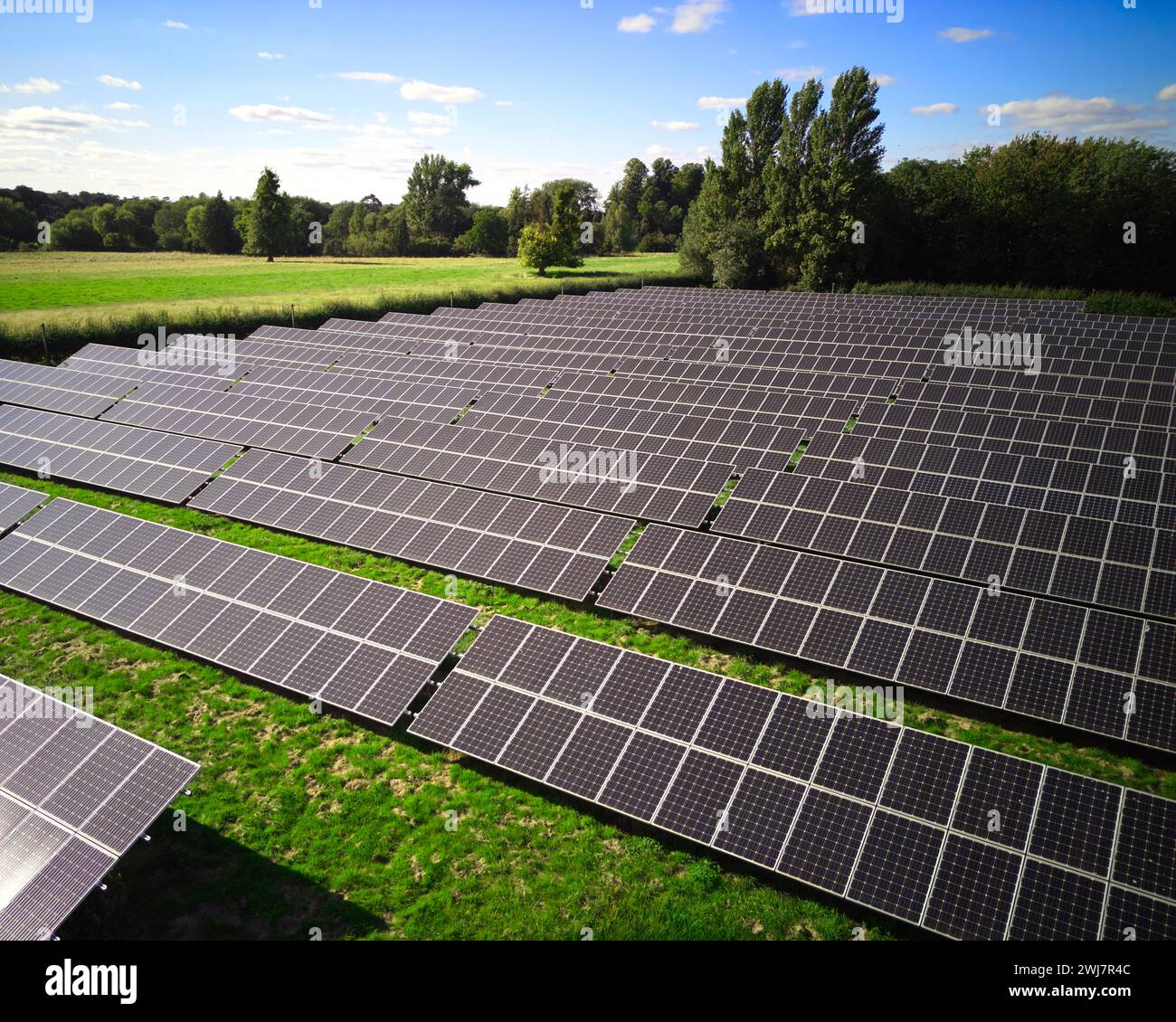 Drone aereo di pannelli solari in campo che generano energia rinnovabile sostenibile in campagna Foto Stock