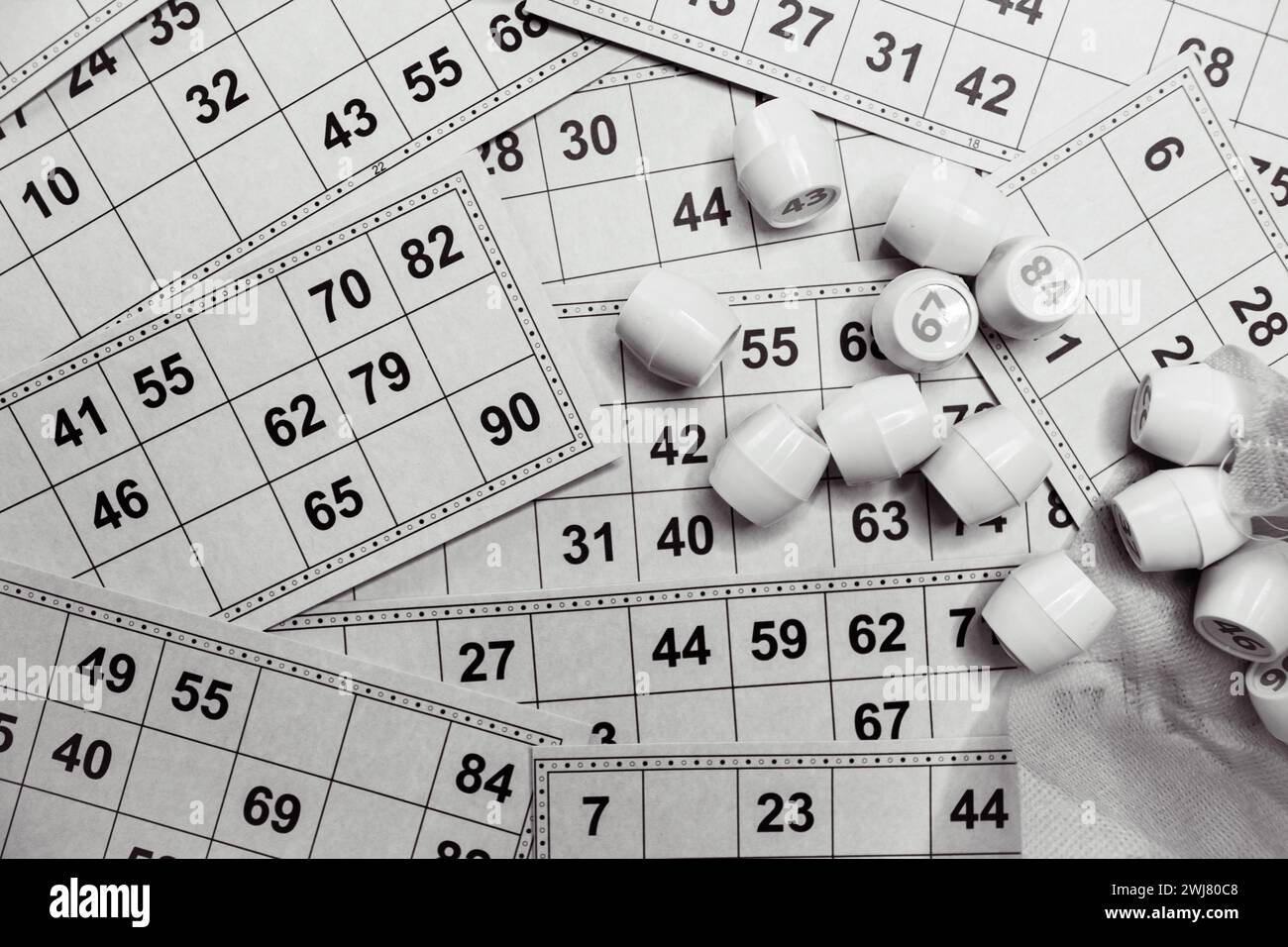 Gioco lotto, monocromatico. Dadi con personaggio sullo sfondo della scheda bingo, bianco e nero. Stile di vita nostalgico. Giochi da tavolo. Giochi retrò. Foto Stock