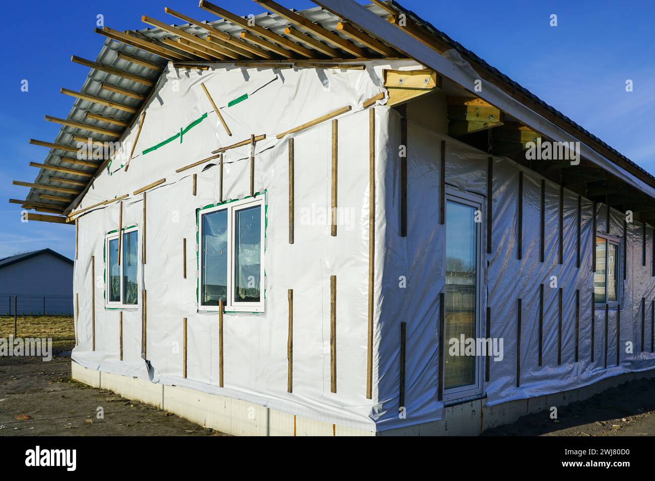 Moderna casa residenziale a un piano senza rifiniture con struttura in legno prima della finitura della facciata Foto Stock