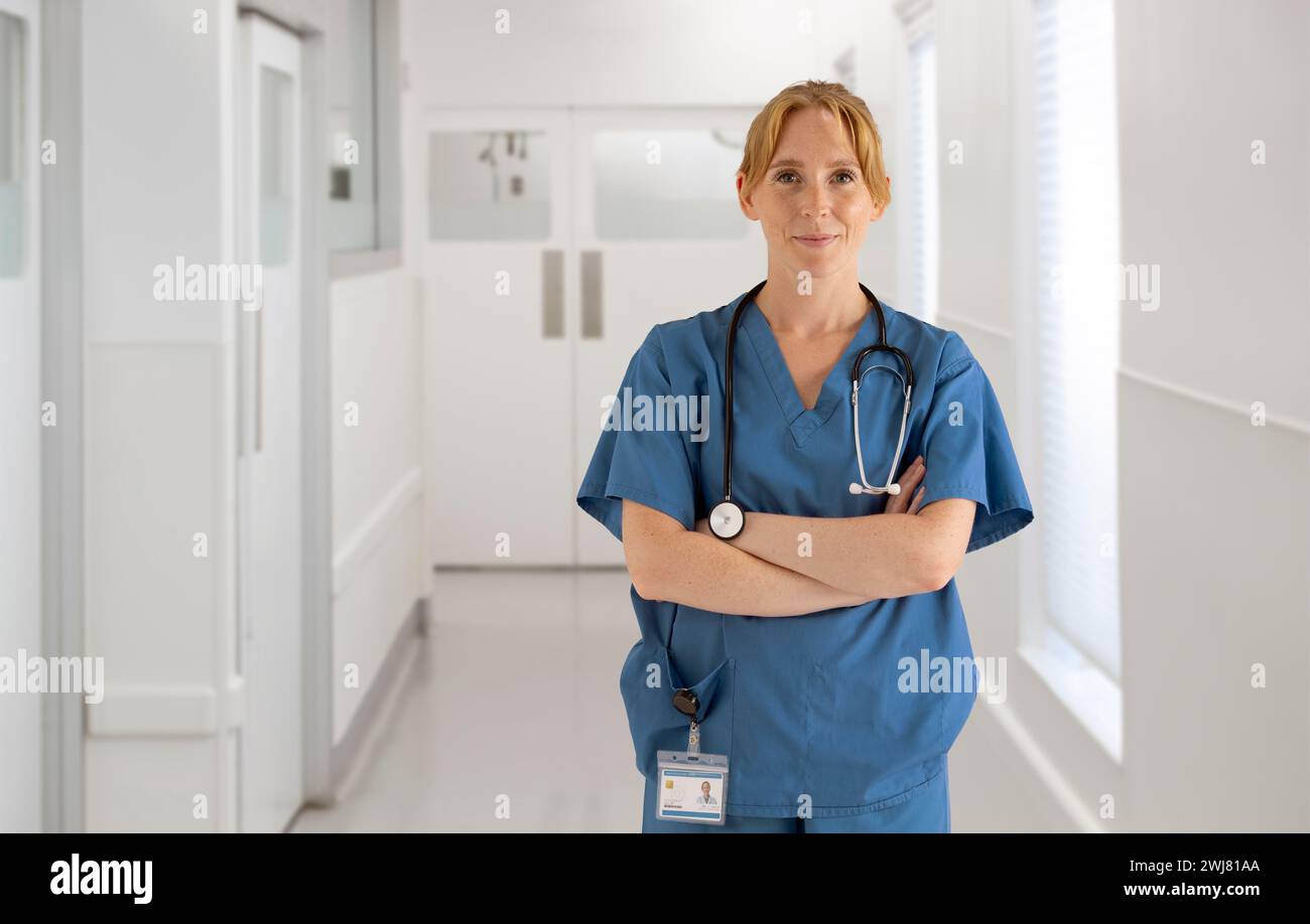 Ritratto di donna medico infermiera o chirurgo che indossa scrub in piedi nel corridoio ospedaliero Foto Stock