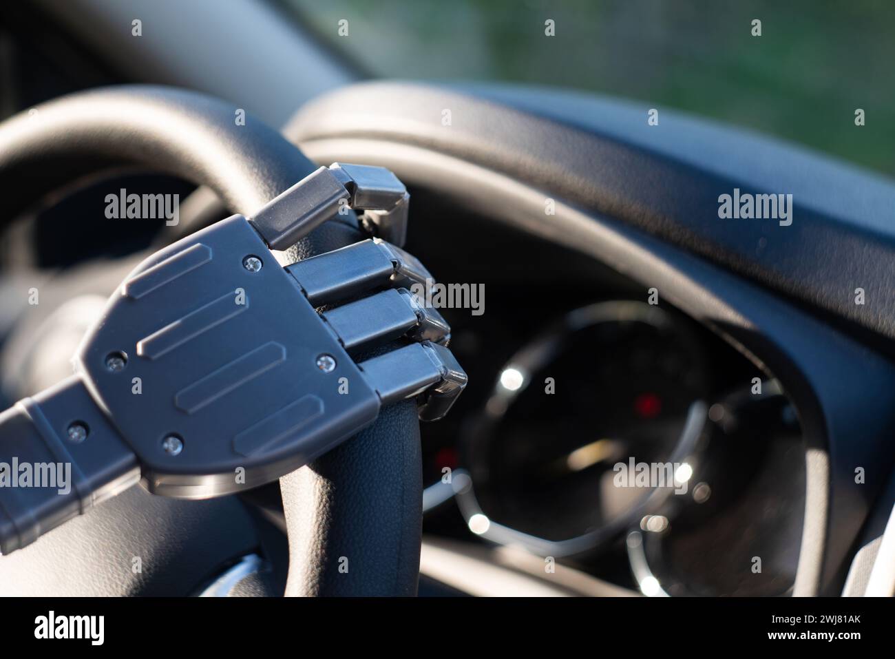 Braccio del robot su un volante. L'intelligenza artificiale guida un'auto. Concetto di veicolo autonomo Foto Stock