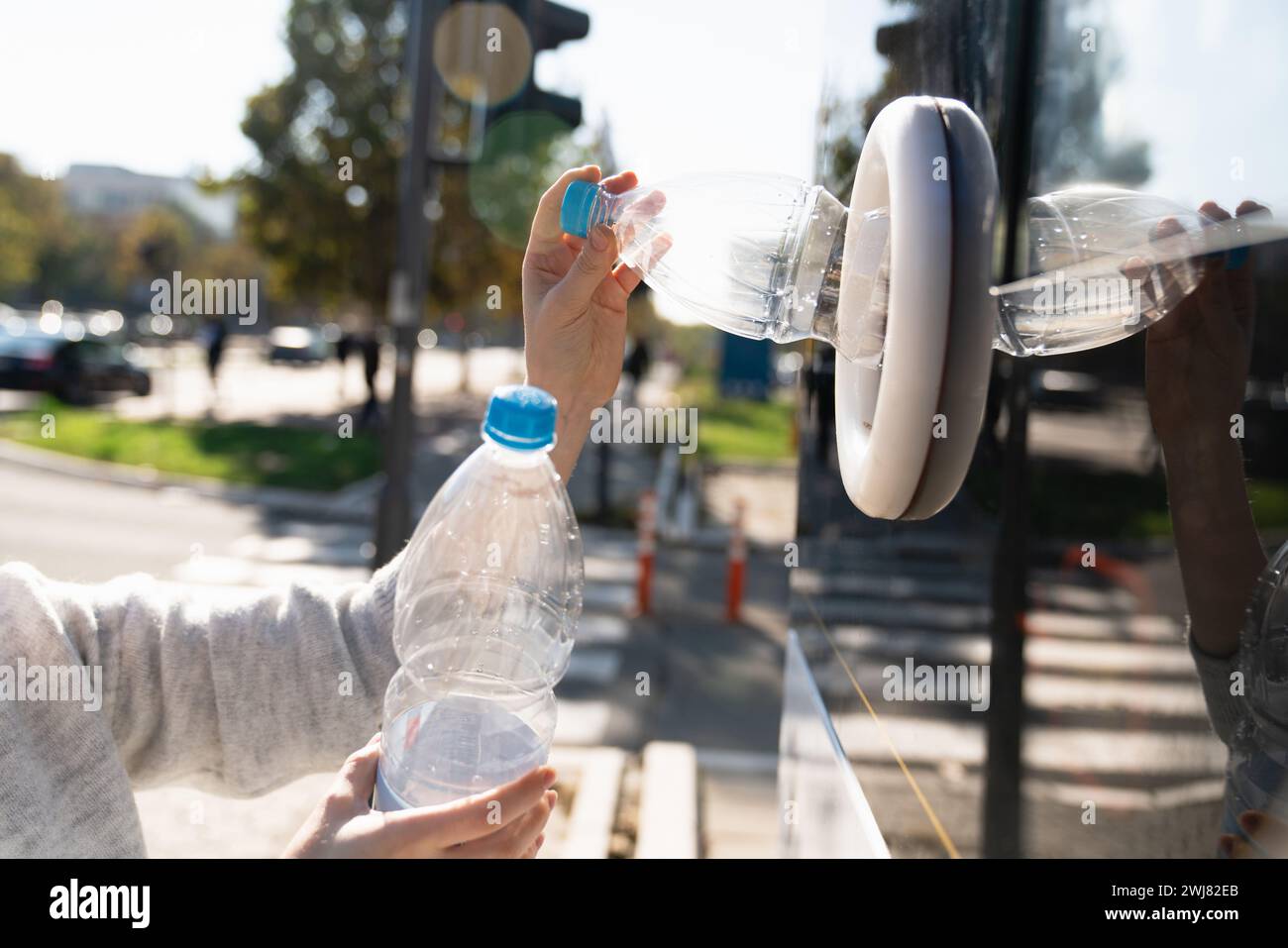 La donna usa una macchina self-service per ricevere bottiglie e lattine di plastica usate in una strada cittadina. Foto Stock