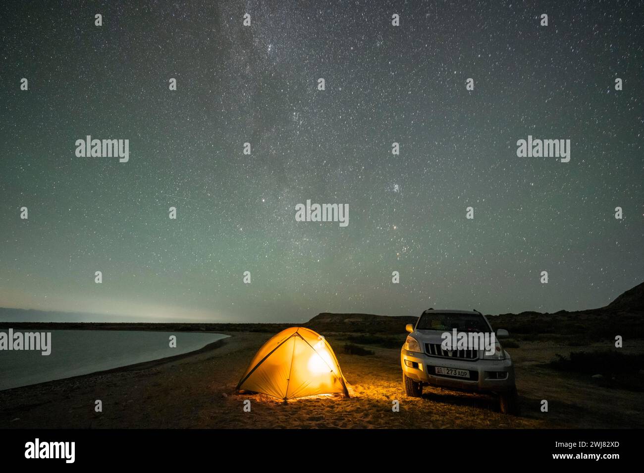 Veicolo fuoristrada e tenda, foto notturna, via Lattea sul lago Issyk Kul, Kirghizistan Foto Stock