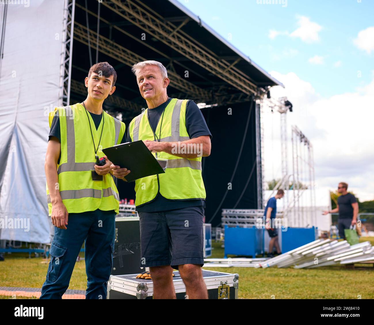 Team di produzione maschile con Flight Cases che allestiscono un palco all'aperto per il Music Festival Foto Stock