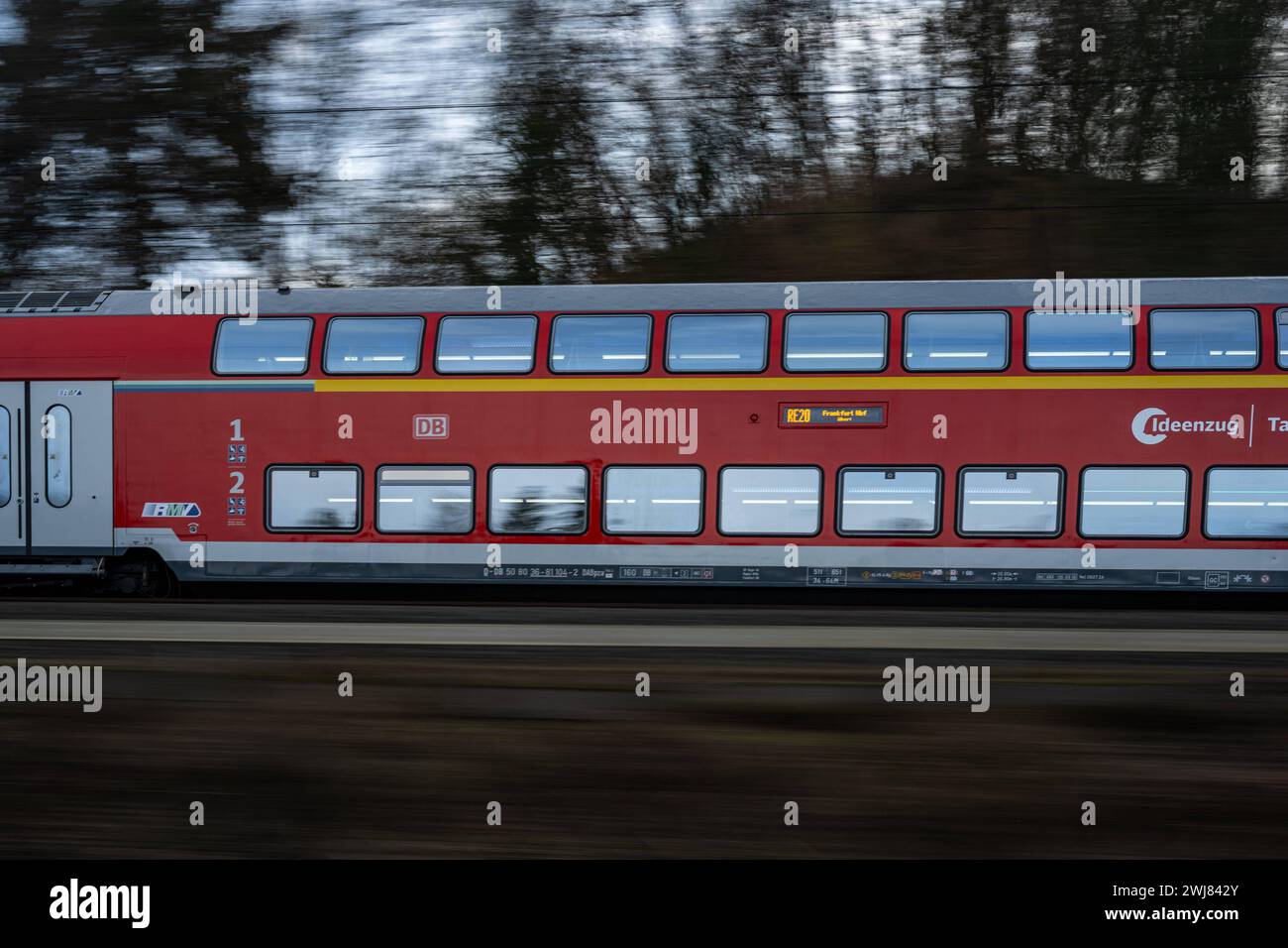 Regionalexpress 20 der Deutschen Bahn auf dem Weg nach Frankfurt 13.02.24, Selters: Symbolfoto, Illustrationsbild, Symbolbild, Illustrationsfoto Regionalexpress 20 der Deutschen Bahn auf dem Weg nach Frankfurt Ein hochmoderner RE20-Zug der Deutschen Bahn durchquert mit hoher Geschwindigkeit eine malerische ländliche Landschen Reschen Reiner Reise Reise Frankfurt. Die Dynamik und Eleganz des Zuges werden durch die Bewegungsunschärfe unterstrichen, während im Hintergrund die ruhige Natur in scharfem Kontrast steht. Selters Hessen Germania *** Regional Express 20 della Deutsche Bahn sulla strada per fra Foto Stock