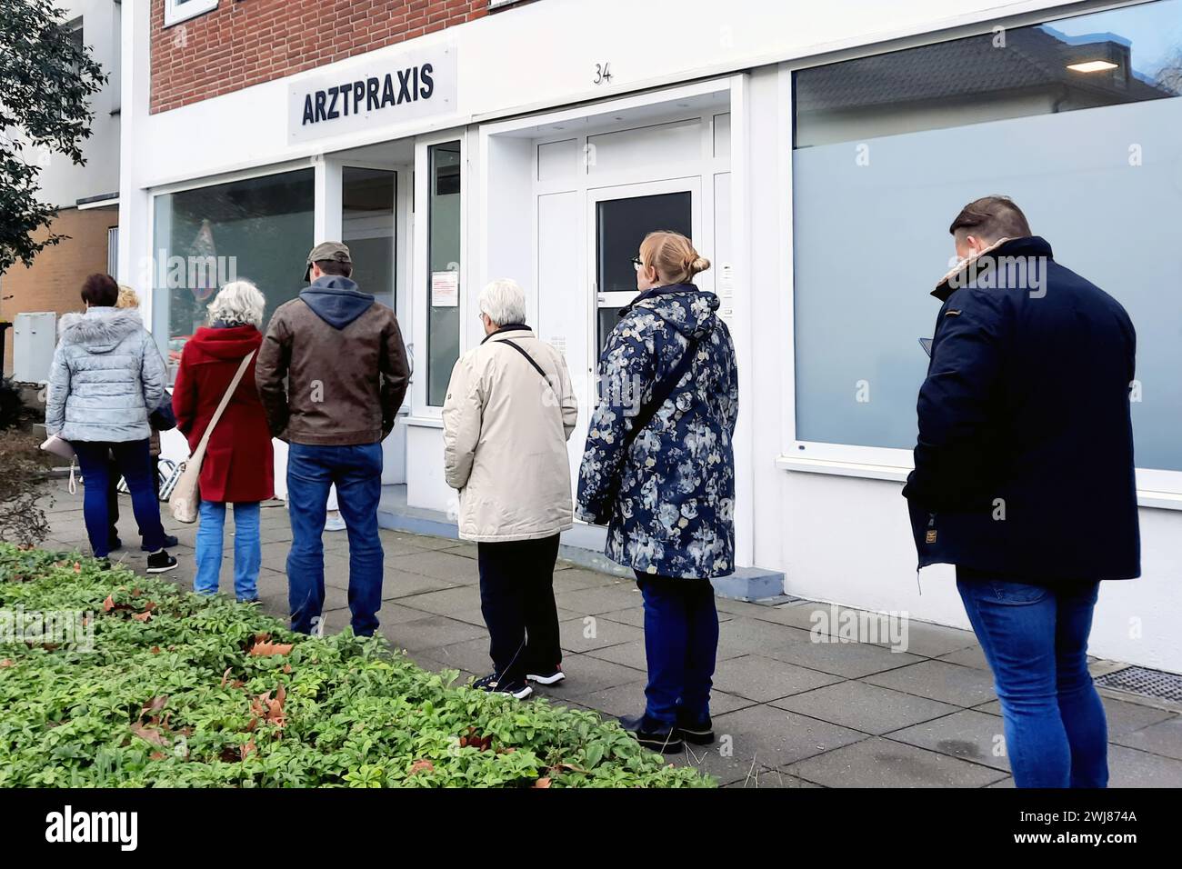 Dortmund, Germania, 13 febbraio 2014: A causa della carenza di assistenti medici MFA e dell'aumento dei tassi di malattia, i pazienti sono in coda fuori dallo studio medico di Dortmund. Foto Stock