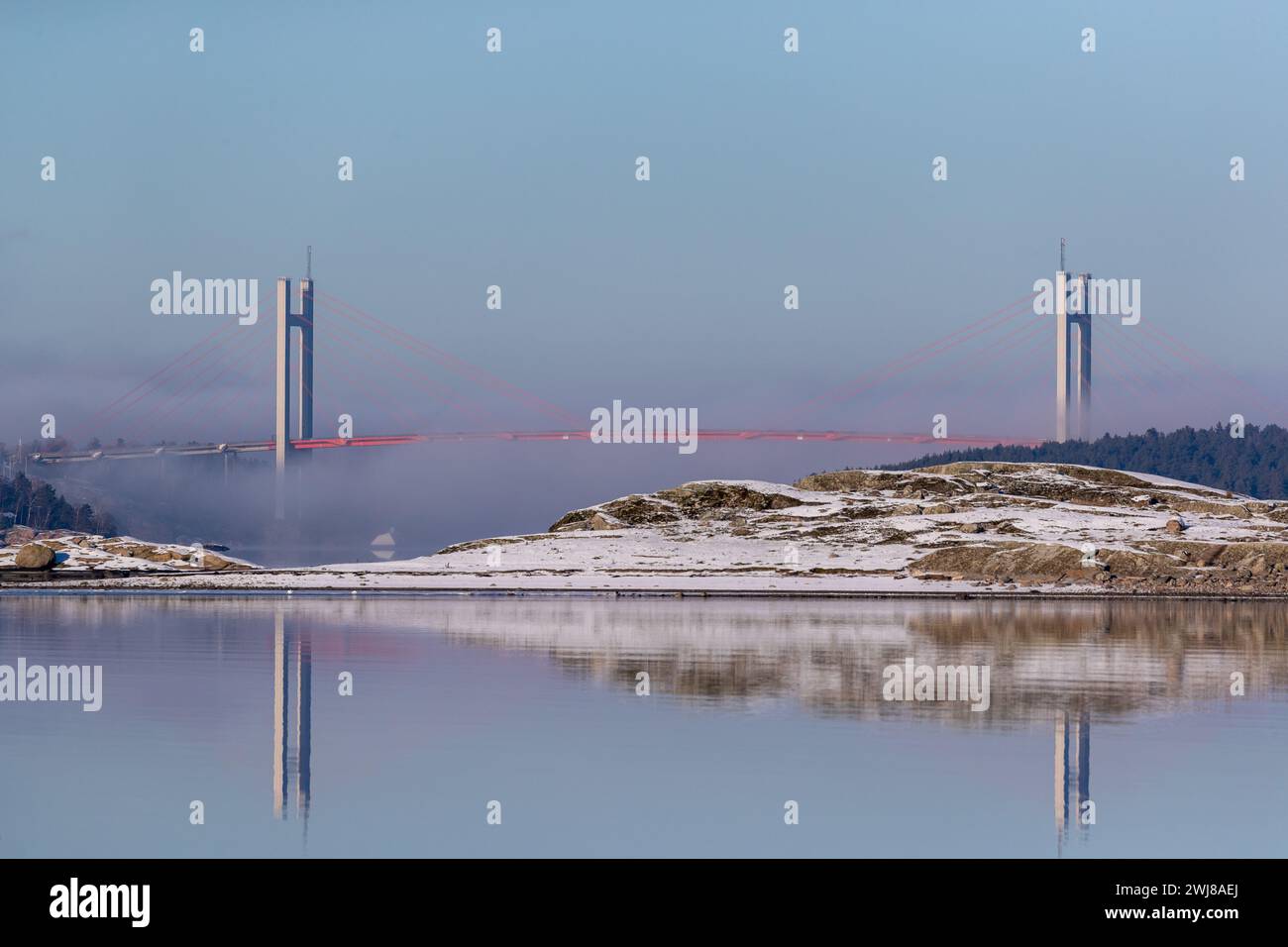 Nebbia sotto il ponte tra la città di Stenungsund e l'isola di Tjörn sulla costa occidentale degli svedesi. Vista sul mare invernale Foto Stock