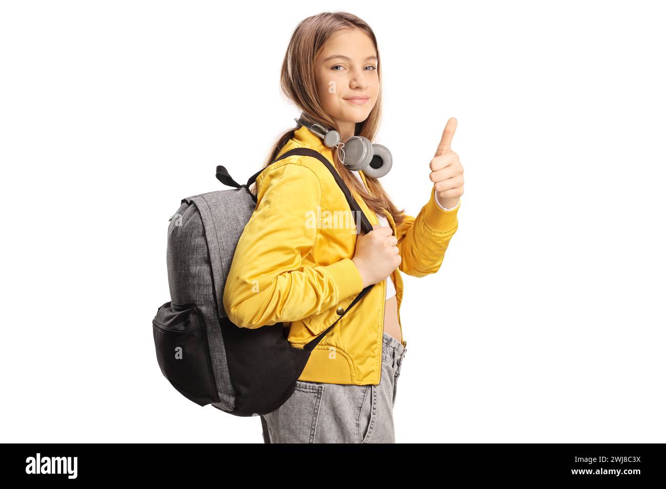 Studentessa adolescente con cuffie e zaino che gestiscono i pollici isolata su sfondo bianco Foto Stock