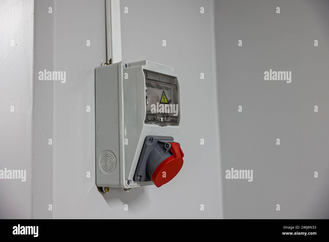Scatola elettrica per esterni con apparecchiature elettriche monofase e trifase e prese di corrente. Connettori trifase. In una fabbrica, rossa e. Foto Stock