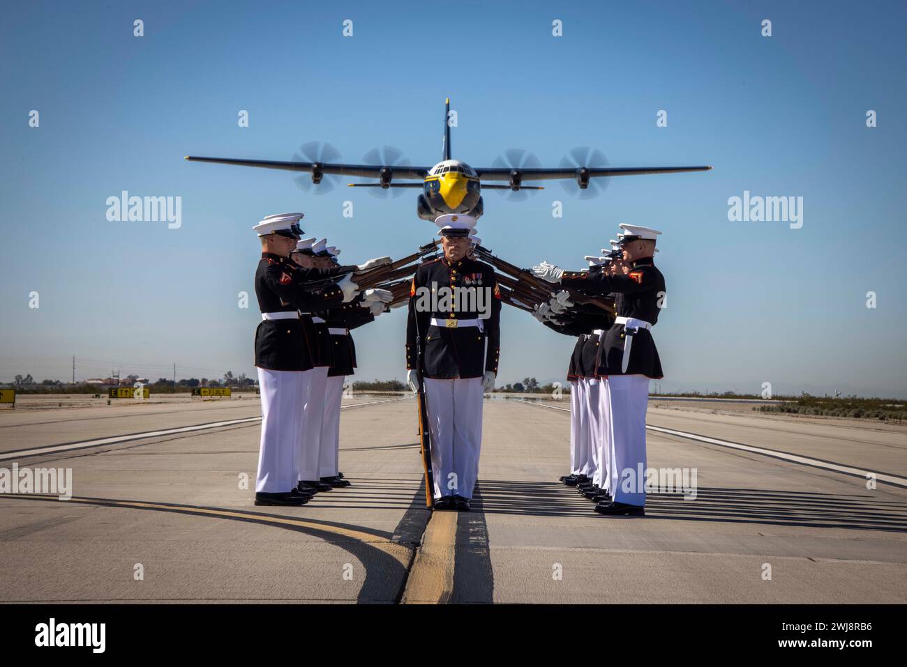 I Marines del Silent Drill Platoon, Marine Barracks Washington, eseguono la loro sequenza di esercitazioni durante il volo dei Blue Angels "Fat Albert" C-130J Super Hercules alla Marine Corps Air Station, Yuma, Ariz., 13 febbraio 2024. Lo spettacolo è stato l'inizio del Battle Color Detachment Tour di quest'anno. (Foto del corpo dei Marines degli Stati Uniti di Lance Cpl. Chloe N. McAfee) Foto Stock