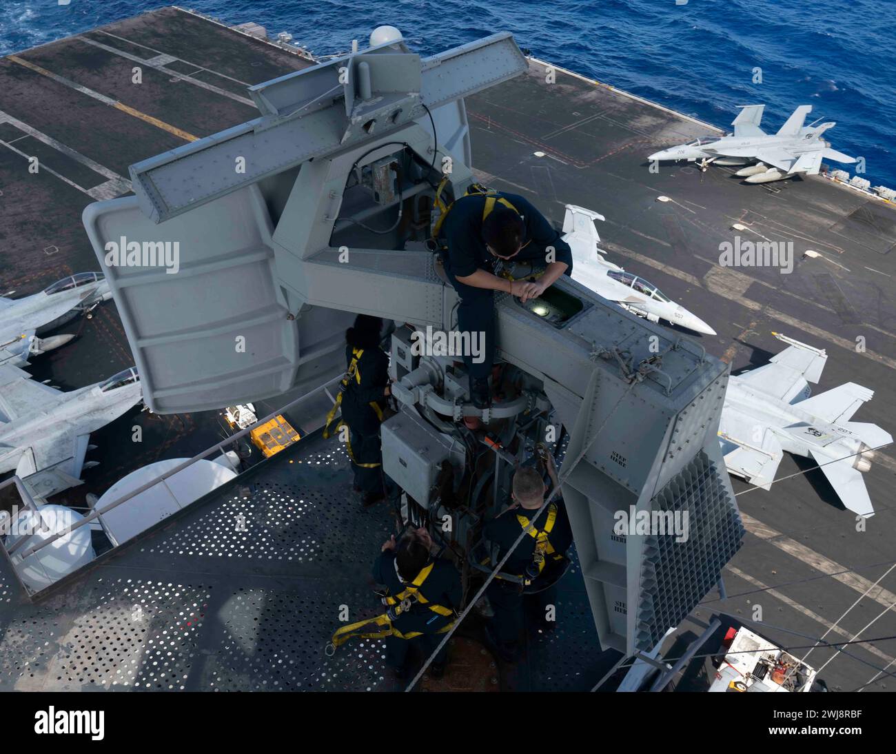 240203-N-PQ495-1035 PHILIPPINE SEA (3 febbraio 2024) i marinai eseguono la manutenzione dell'anthe AN/SPN-43 Marshal radar sull'albero della portaerei classe Nimitz USS Carl Vinson (CVN 70). Vinson, nave ammiraglia del Carrier Strike Group ONE, è dispiegata nell'area delle operazioni della 7th Fleet degli Stati Uniti a supporto di un Indo-Pacifico libero e aperto. (Foto della Marina degli Stati Uniti di Larissa T. Dougherty, specialista della comunicazione di massa di seconda classe) Foto Stock