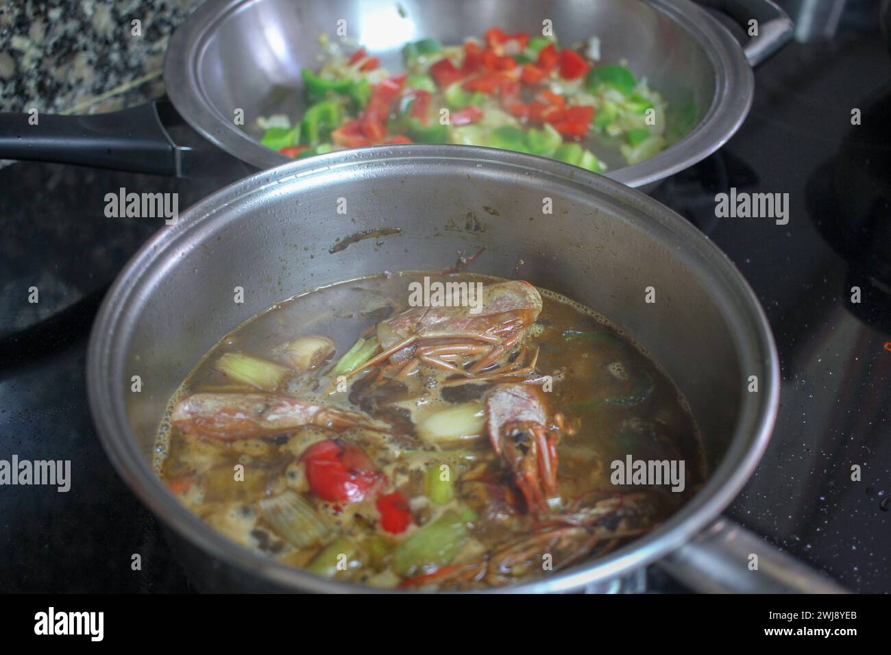 Un capolavoro culinario si dispiega come pesce e pesce sobbollire, infondendo l'aria con un aroma allettante per un delizioso piatto di riso Foto Stock