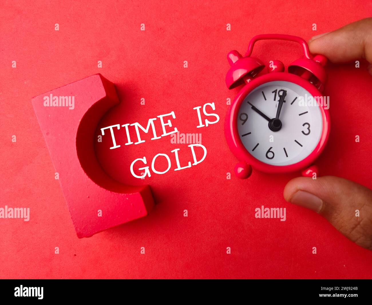 La visualizzazione dall'alto dell'orologio con il testo DELL'ORA È IN ORO su sfondo rosso. Foto Stock