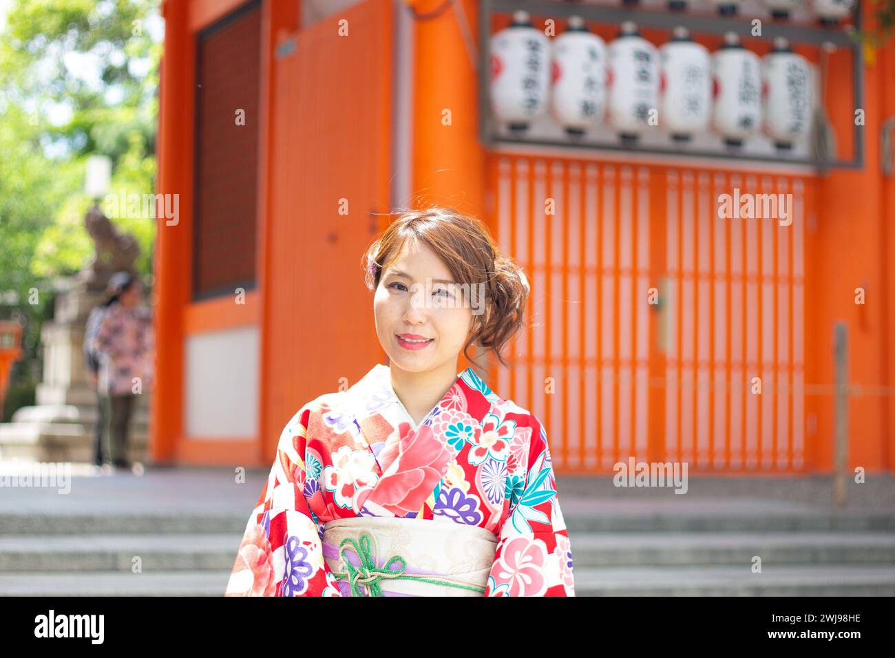 Bella ragazza che indossa un abito tradizionale giapponese (Kimono) di fronte al cancello del santuario Yasaka Jinja, Kyoto, Giappone Foto Stock