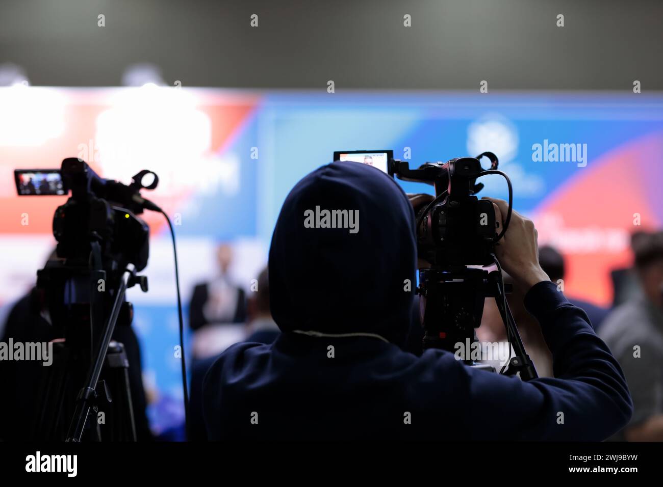 Operatore di telecamere di notizie televisive che trasmette eventi in diretta. Messa a fuoco selettiva. Foto Stock